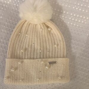 Steve Madden Cream Knit Pom Pom Beanie with rhinestone and pearl accents.